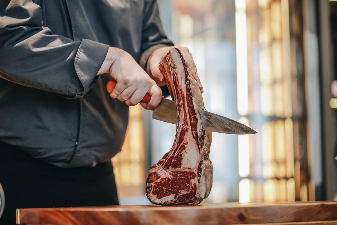 a chef cutting beef steak in a Hanoi hotel restaurant